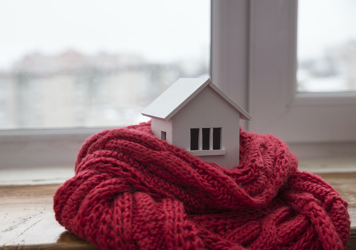 Model house wrapped in a red knitted scarf